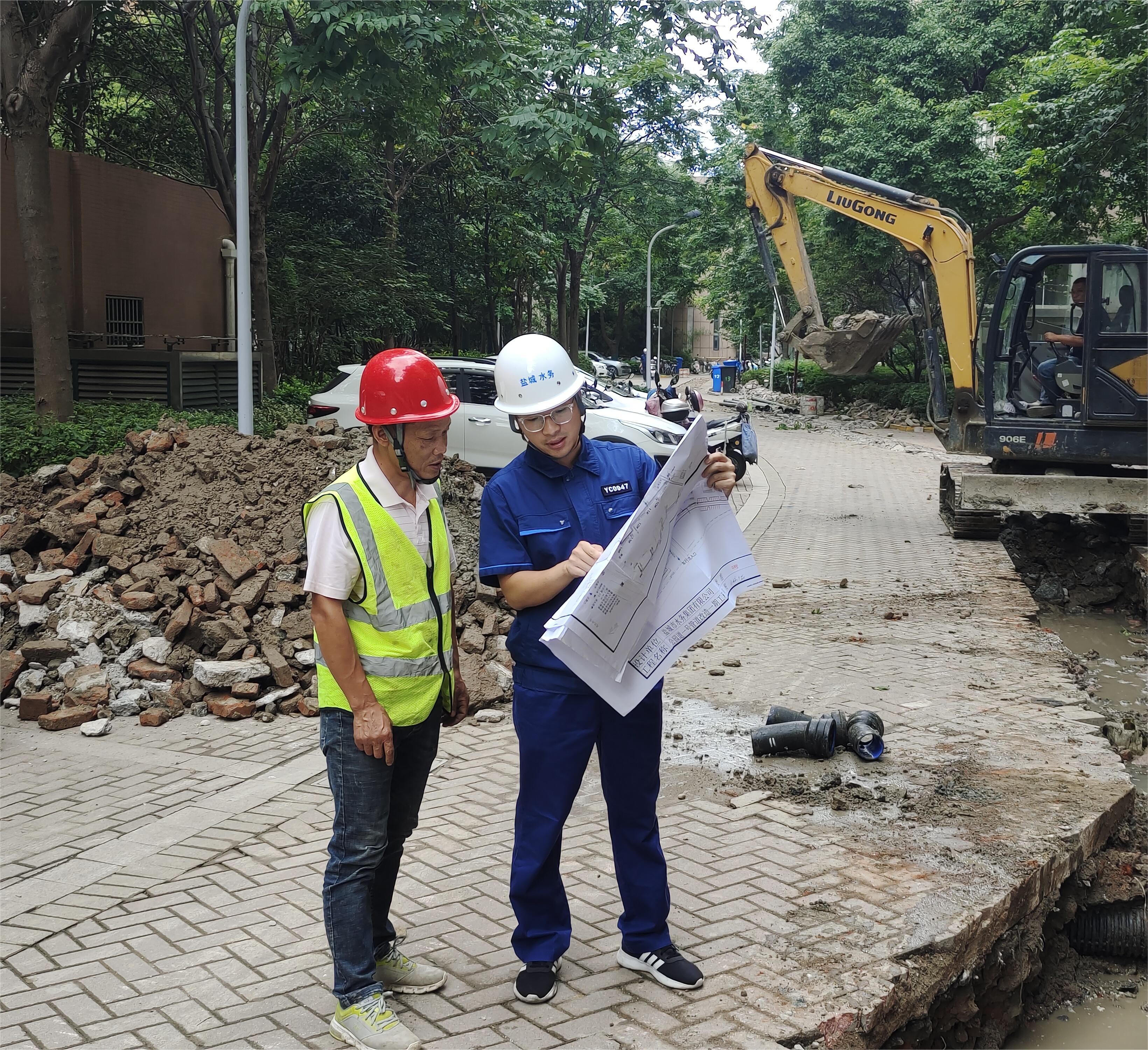 孟偉（右一）在公園道一號小區(qū)組織施工方按圖施工.jpg